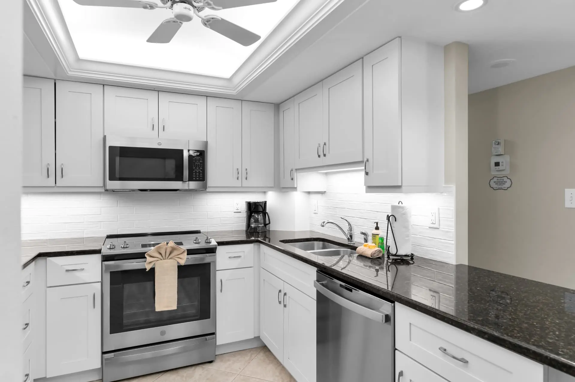 Kitchen with white shaker cabinets, granite countertops and stainless steel appliances